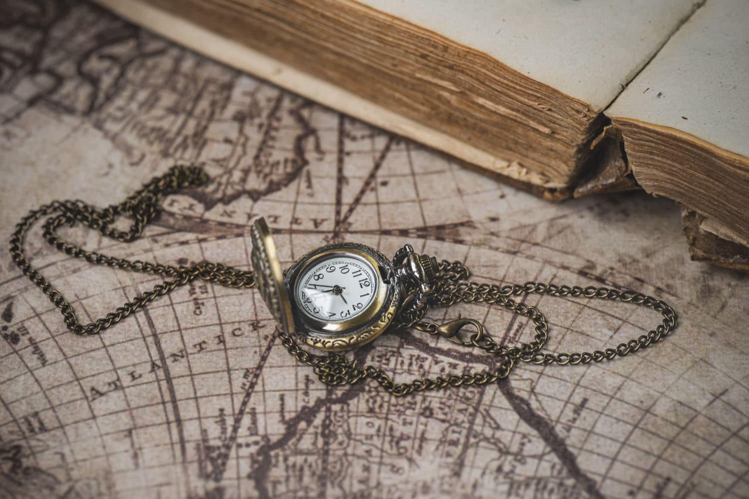 Vintage-Taschenuhr auf einer antiken Landkarte – Sinnbild für Uhren mit Geschichte